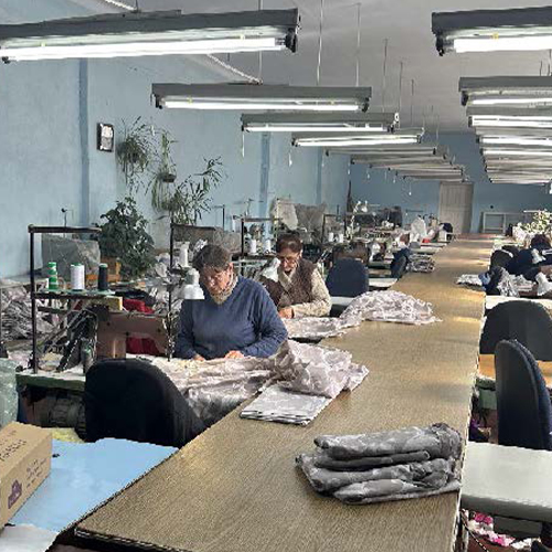 Women are sewing mattress covers in an assembly line