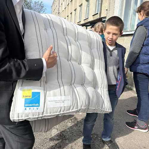 Young boy holds a mattress